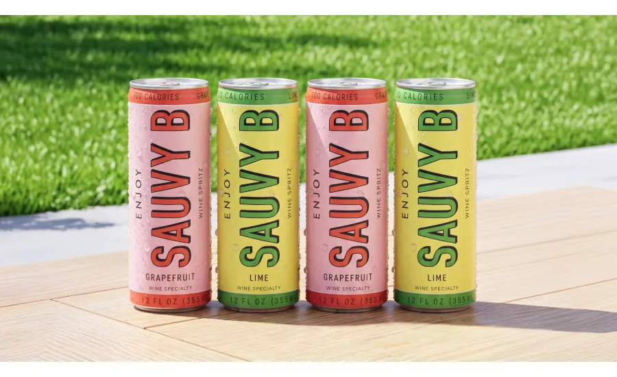 Two Sauvy B Grapefruit and two Sauvy B Lime flavor cans aligned with each other in an alternating arrangement on a wooden table with green grass in the background